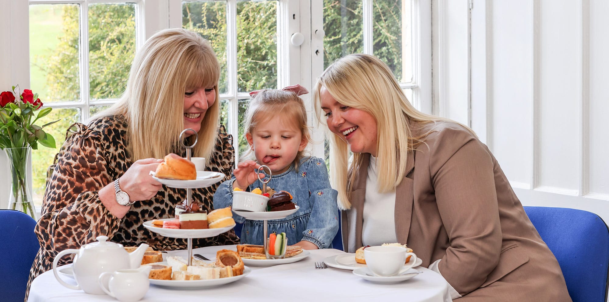 Two women and a child enjoying afternoon tea at Marwell Hall