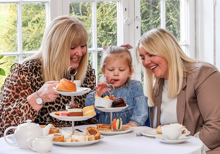 Two women and a child enjoying afternoon tea at Marwell Hall