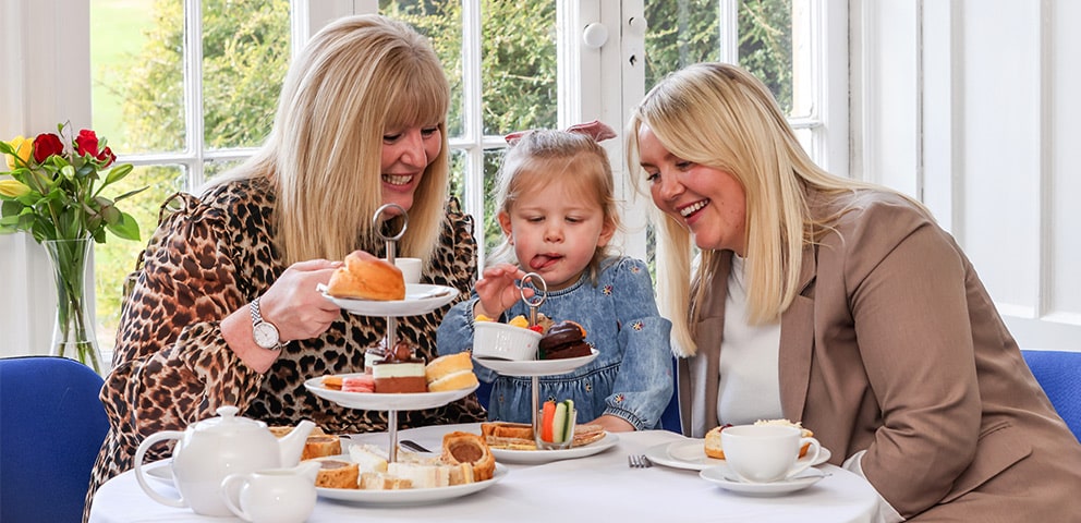 Two women and a child enjoying afternoon tea at Marwell Hall
